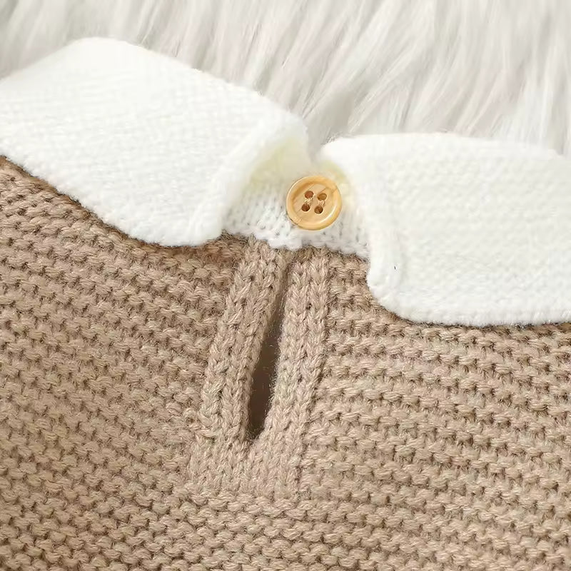 Close-up of a beige knitted garment with white trim and a button.