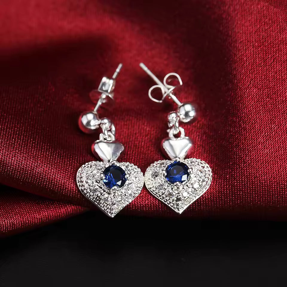 Close-up of 925 sterling silver jewelry set highlighting blue crystal heart pendant necklace and matching earrings for classic fashion gift.